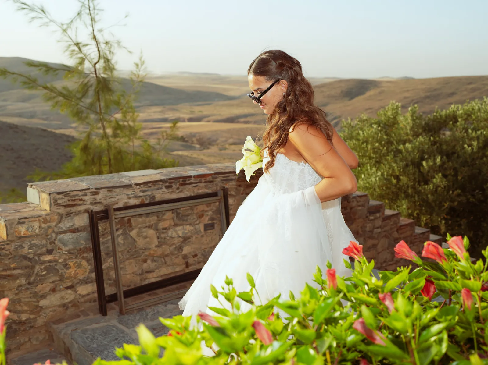 Bride on a stone terrace overlooking the Agafay desert hills at golden hour