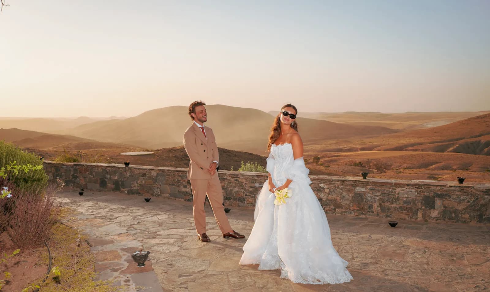 Couple portrait on a terrace with a sweeping Agafay desert panorama behind
