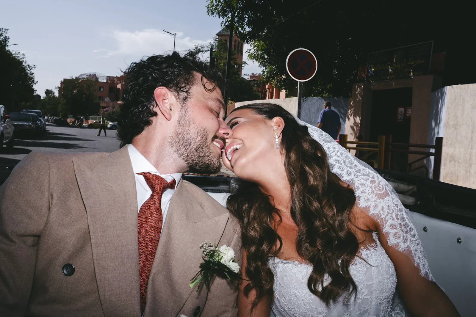 Newlyweds laughing in a vintage convertible on the streets of Marrakech