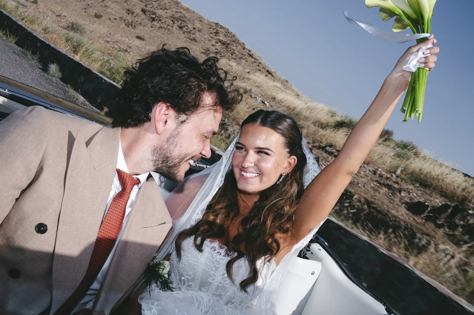 Couple in a classic convertible by the desert hills, Marrakech wedding