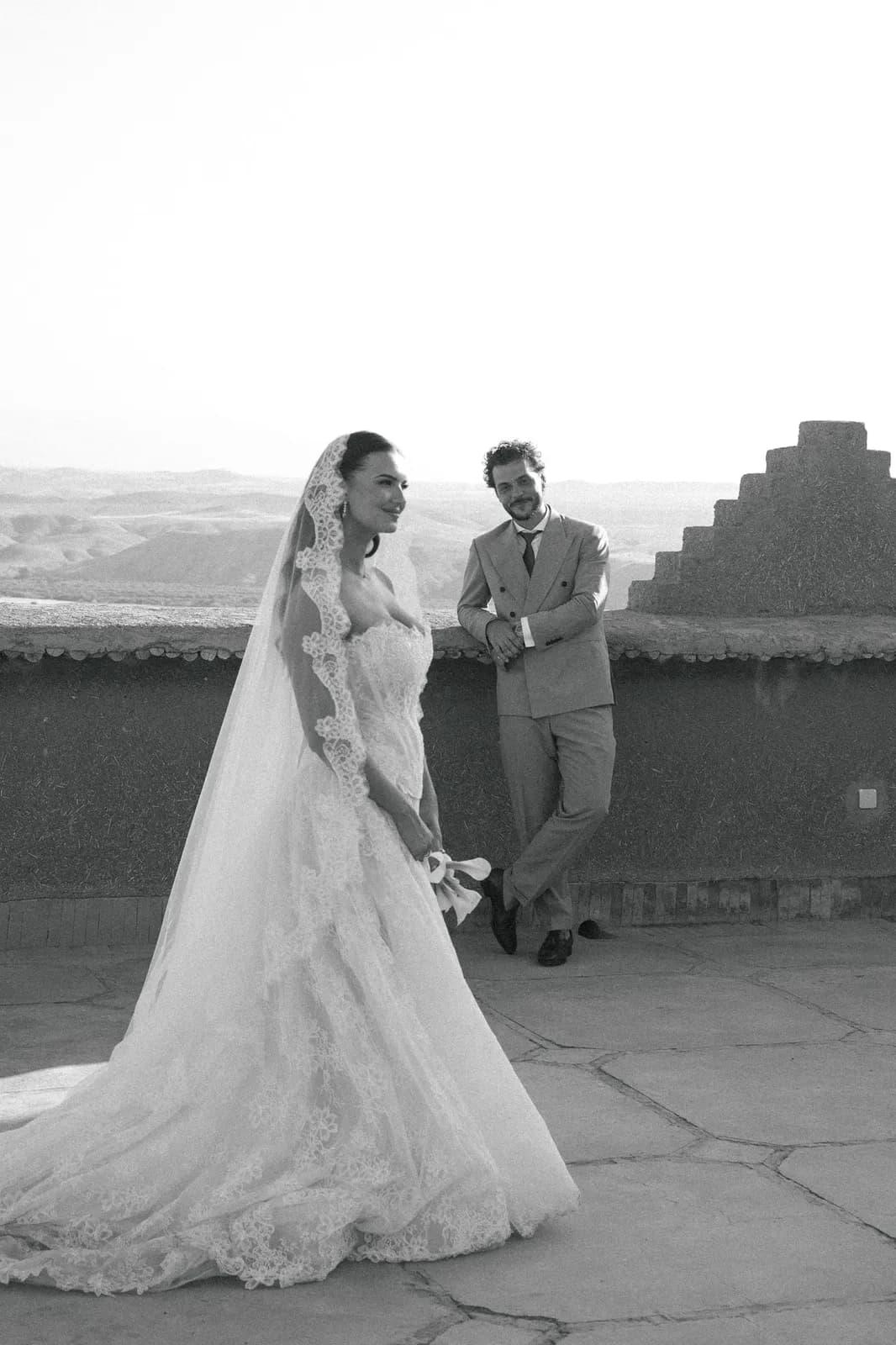 Black and white portrait of the couple on a kasbah rooftop above the desert
